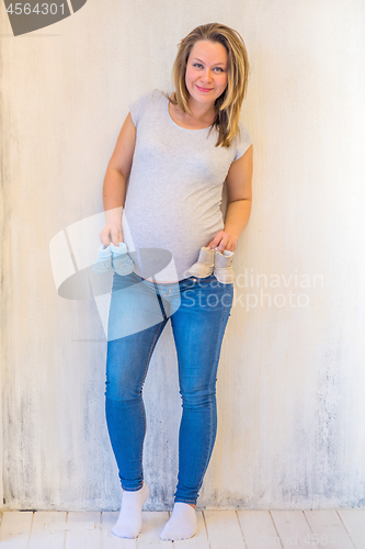 Image of Beautiful pregnant woman standing near wall
