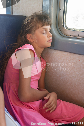 Image of Tired girl fell asleep in an electric train