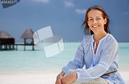 Image of happy woman over tropical beach and bungalow