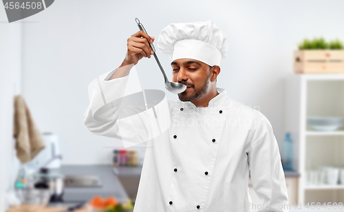 Image of indian chef tasting food from ladle at kitchen