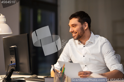 Image of businessman with computer working at night office