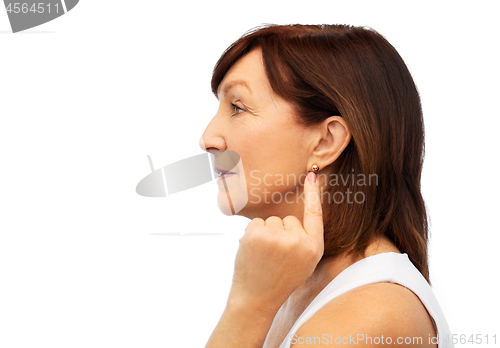 Image of senior woman pointing to her golden earring