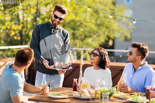 Image of friends at bbq party on rooftop in summer