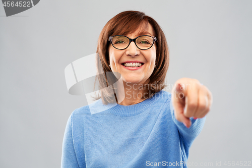 Image of senior woman in glasses pointing finger to you