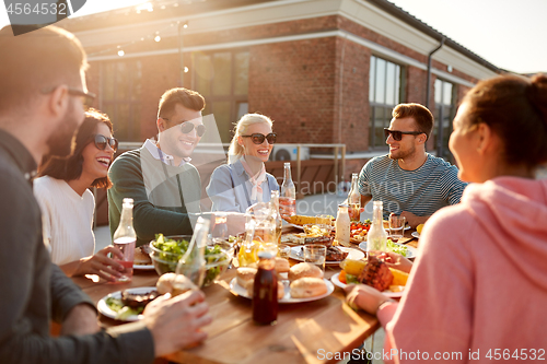 Image of happy friends with drinks or bbq party on rooftop