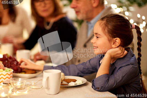 Image of happy girl having tea party with family at home