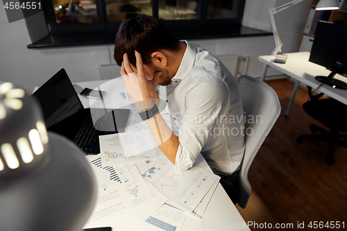 Image of businessman with papers working at night office