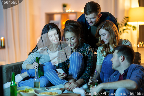 Image of friends with smartphone watching tv at home