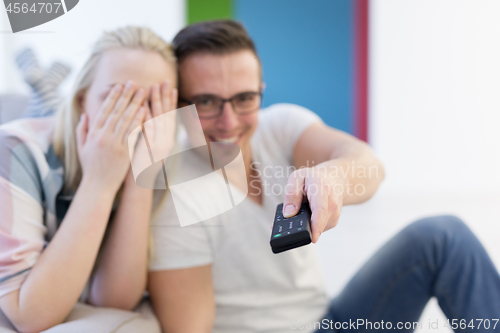 Image of Young couple on the sofa watching television