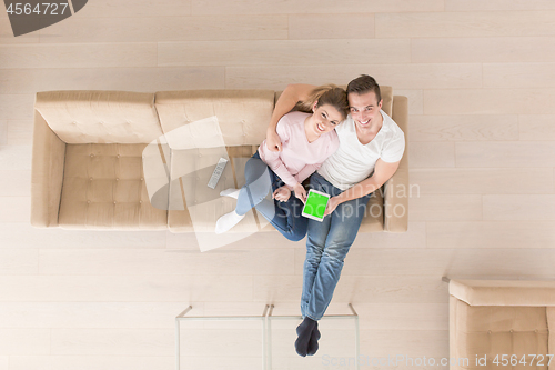 Image of young couple in living room using tablet top view