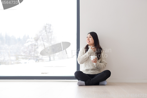 Image of asian woman enjoying morning coffee