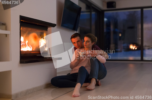 Image of happy couple in front of fireplace