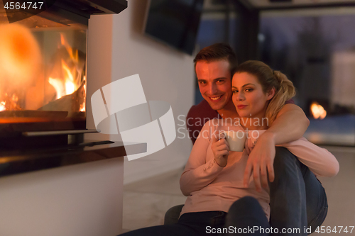 Image of happy couple in front of fireplace