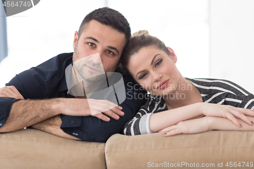 Image of Portrait of young couple sitting on sofa