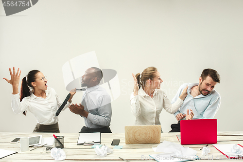 Image of Young men and women sitting at office and working on laptops. Emotions concept