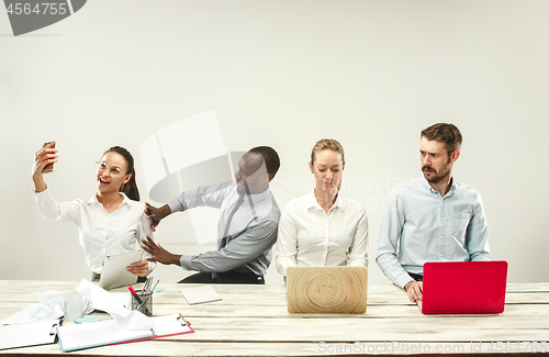 Image of Young men and women sitting at office and working on laptops. Emotions concept