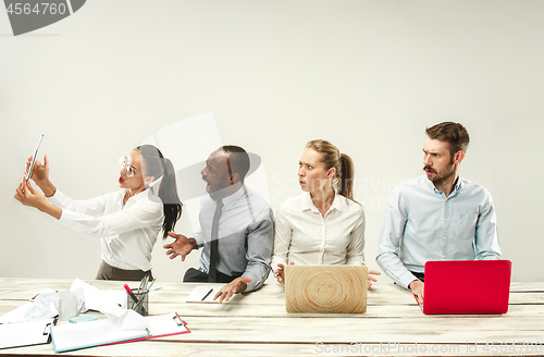 Image of Young men and women sitting at office and working on laptops. Emotions concept