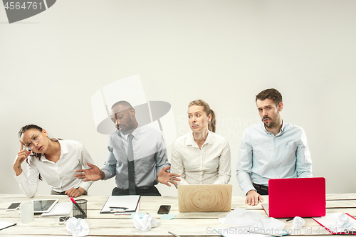 Image of Young men and women sitting at office and working on laptops. Emotions concept