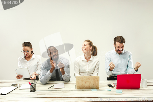 Image of Young men and women sitting at office and working on laptops. Emotions concept