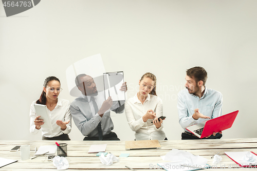 Image of Young men and women sitting at office and working on laptops. Emotions concept