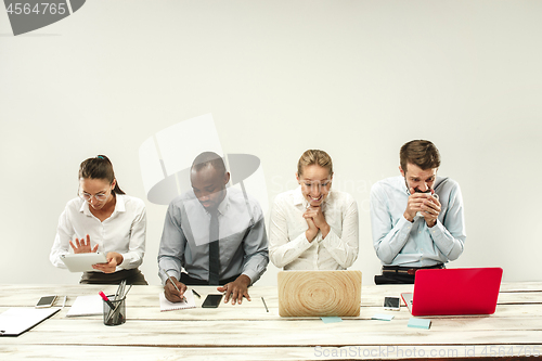 Image of Young men and women sitting at office and working on laptops. Emotions concept