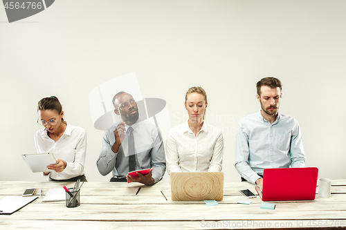 Image of Young men and women sitting at office and working on laptops. Emotions concept