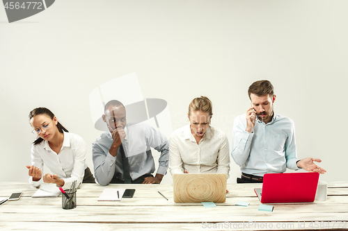 Image of Young men and women sitting at office and working on laptops. Emotions concept