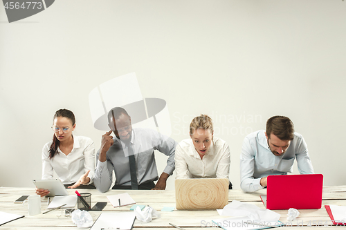 Image of Young men and women sitting at office and working on laptops. Emotions concept