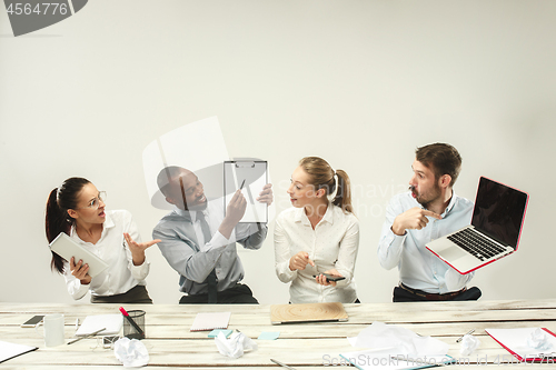 Image of Young men and women sitting at office and working on laptops. Emotions concept