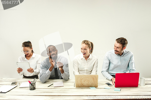 Image of Young men and women sitting at office and working on laptops. Emotions concept