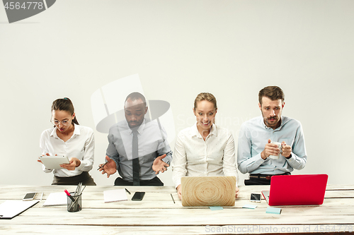 Image of Young men and women sitting at office and working on laptops. Emotions concept