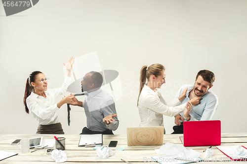 Image of Young men and women sitting at office and working on laptops. Emotions concept