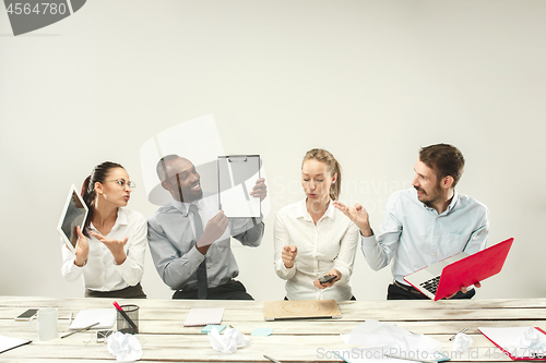 Image of Young men and women sitting at office and working on laptops. Emotions concept