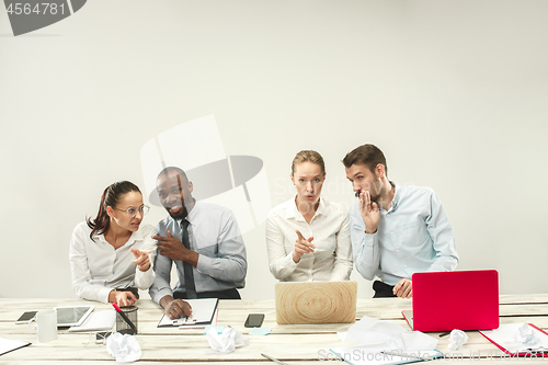 Image of Young men and women sitting at office and working on laptops. Emotions concept