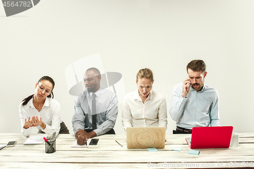 Image of Young men and women sitting at office and working on laptops. Emotions concept