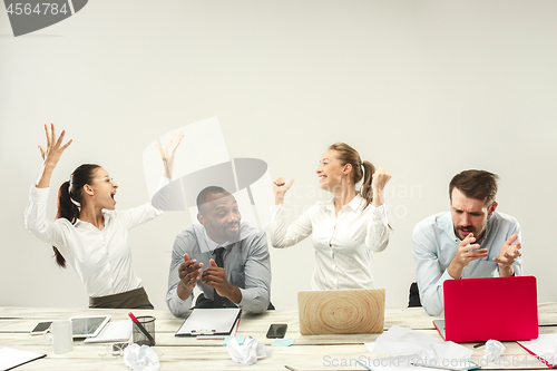 Image of Young men and women sitting at office and working on laptops. Emotions concept