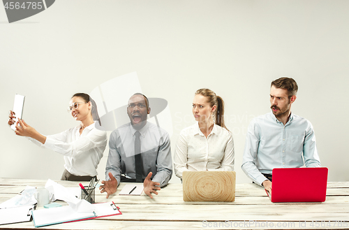 Image of Young men and women sitting at office and working on laptops. Emotions concept