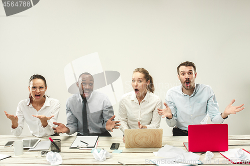 Image of Young men and women sitting at office and working on laptops. Emotions concept