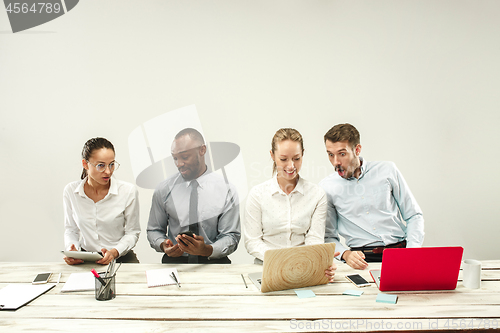 Image of Young men and women sitting at office and working on laptops. Emotions concept