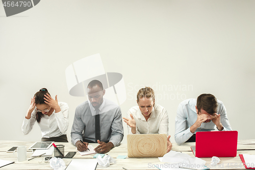 Image of Young men and women sitting at office and working on laptops. Emotions concept