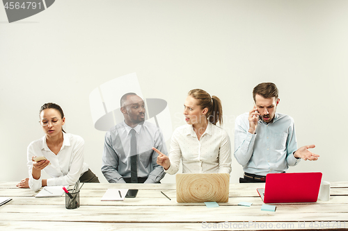 Image of Young men and women sitting at office and working on laptops. Emotions concept