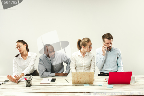 Image of Young men and women sitting at office and working on laptops. Emotions concept