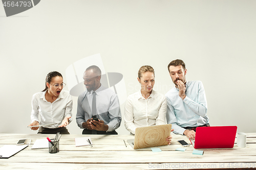 Image of Young men and women sitting at office and working on laptops. Emotions concept