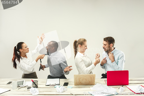 Image of Young men and women sitting at office and working on laptops. Emotions concept