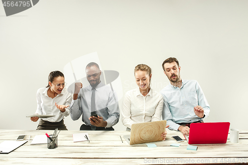 Image of Young men and women sitting at office and working on laptops. Emotions concept