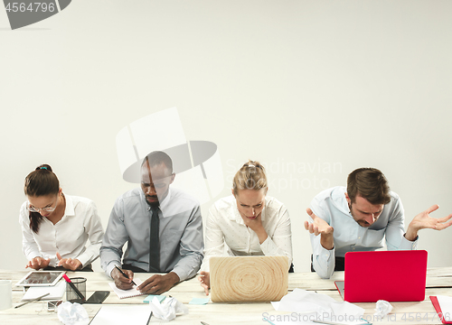 Image of Young men and women sitting at office and working on laptops. Emotions concept