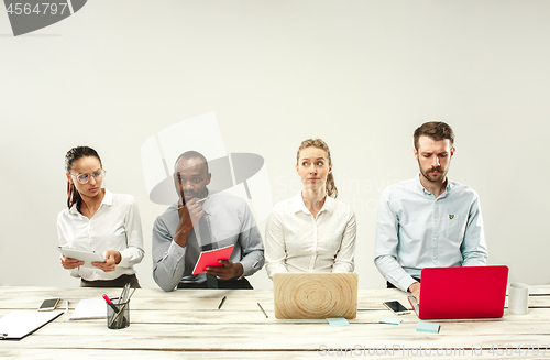 Image of Young men and women sitting at office and working on laptops. Emotions concept