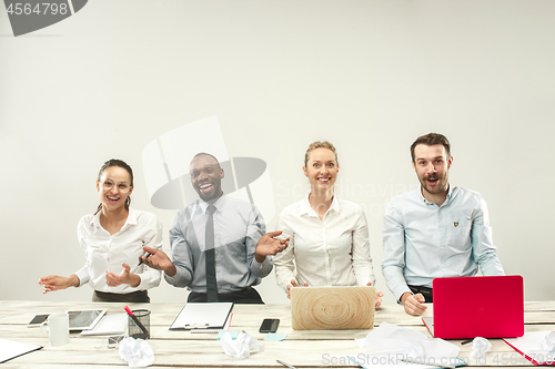 Image of Young men and women sitting at office and working on laptops. Emotions concept