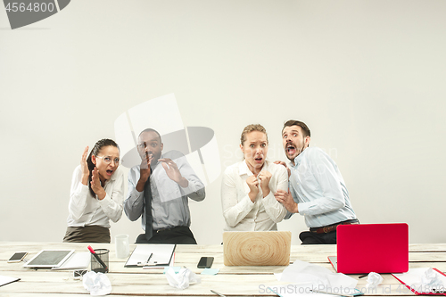 Image of Young men and women sitting at office and working on laptops. Emotions concept