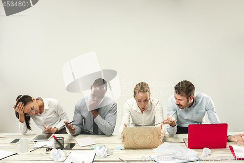 Image of Young men and women sitting at office and working on laptops. Emotions concept